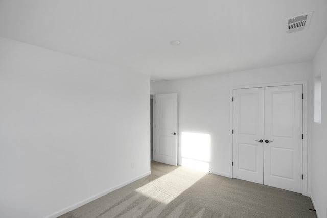 unfurnished bedroom featuring a closet and light carpet