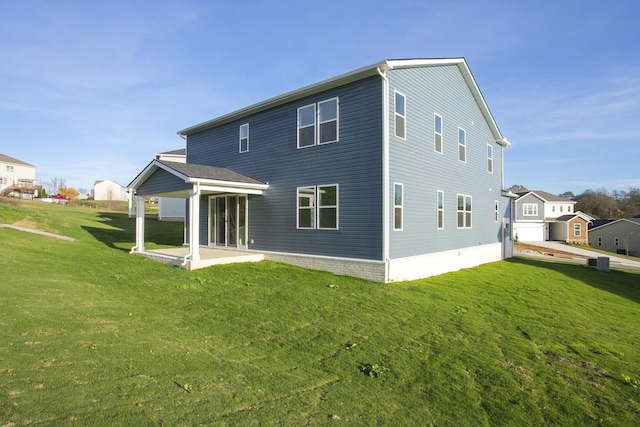 rear view of property with a lawn and a patio