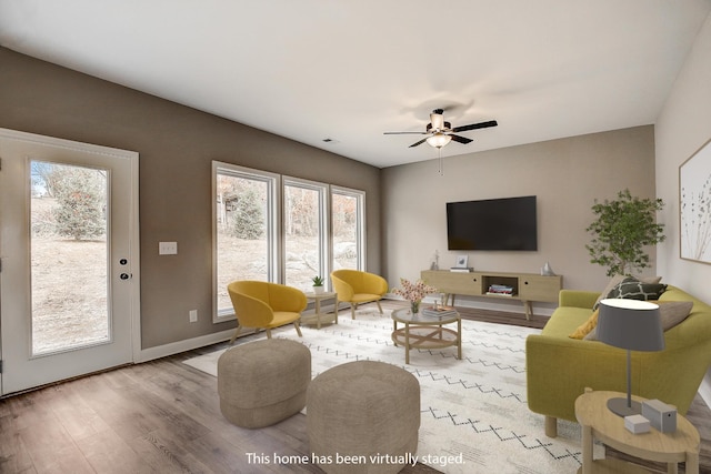 living room featuring ceiling fan and light hardwood / wood-style floors