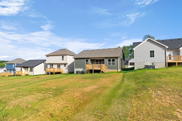 back of property featuring a lawn, central AC, and a deck