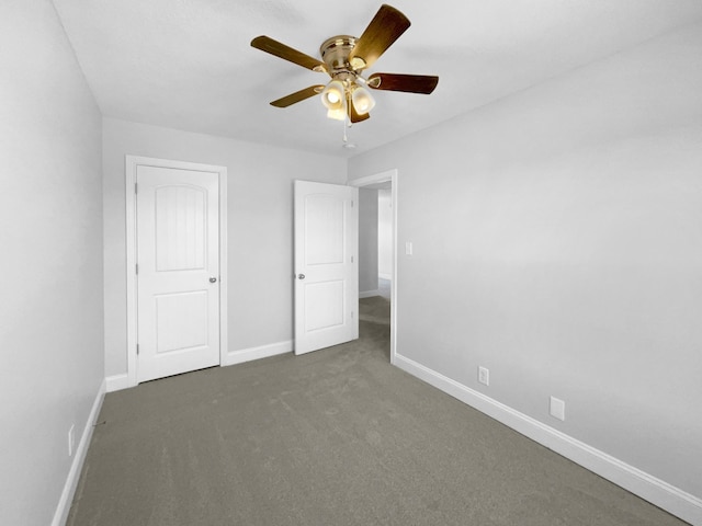 unfurnished bedroom with ceiling fan and dark carpet