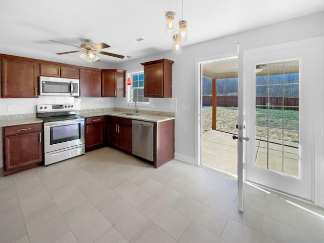 kitchen featuring ceiling fan, appliances with stainless steel finishes, hanging light fixtures, and sink