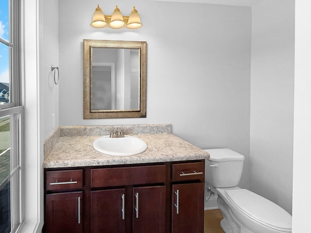 bathroom featuring plenty of natural light, toilet, and vanity