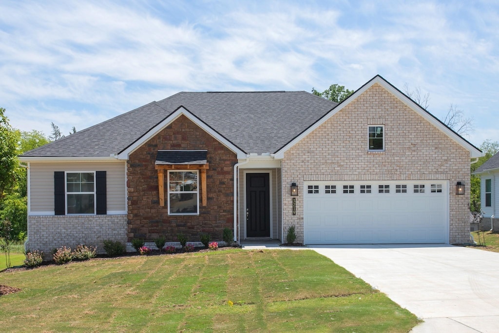 view of front of home featuring a front lawn and a garage