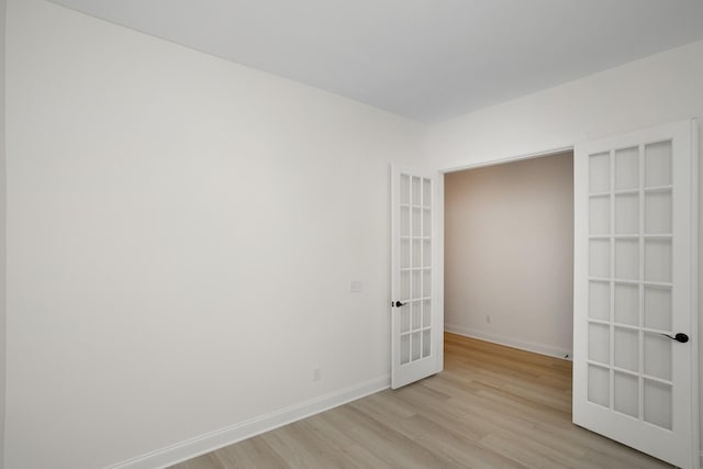 unfurnished room featuring french doors and light wood-type flooring