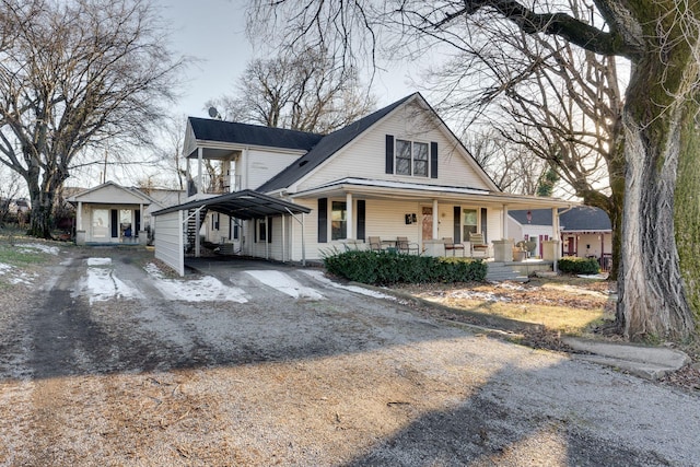 view of front of home with an outbuilding, a porch, and a carport