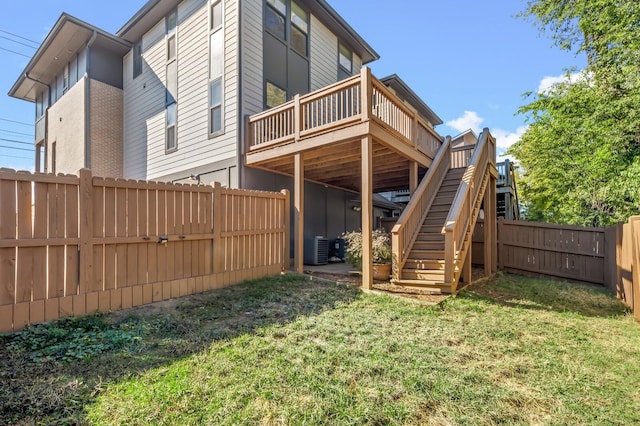 back of property featuring central AC unit, a lawn, and a wooden deck