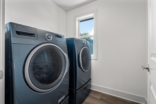 laundry room with dark hardwood / wood-style flooring and washing machine and dryer