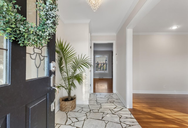 entryway featuring wood-type flooring, a chandelier, and ornamental molding