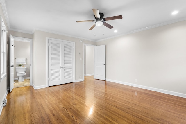 unfurnished bedroom with connected bathroom, a closet, light wood-type flooring, crown molding, and ceiling fan