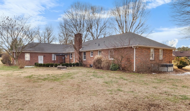 back of house featuring central air condition unit and a yard