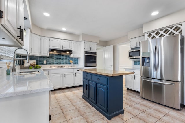 kitchen with sink, a kitchen island, white cabinets, and appliances with stainless steel finishes