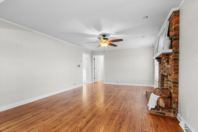 unfurnished living room featuring wood-type flooring, ornamental molding, and ceiling fan