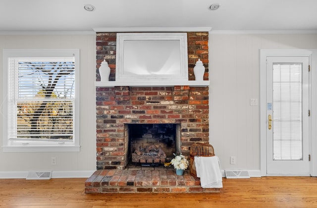 room details with a brick fireplace, ornamental molding, and hardwood / wood-style flooring