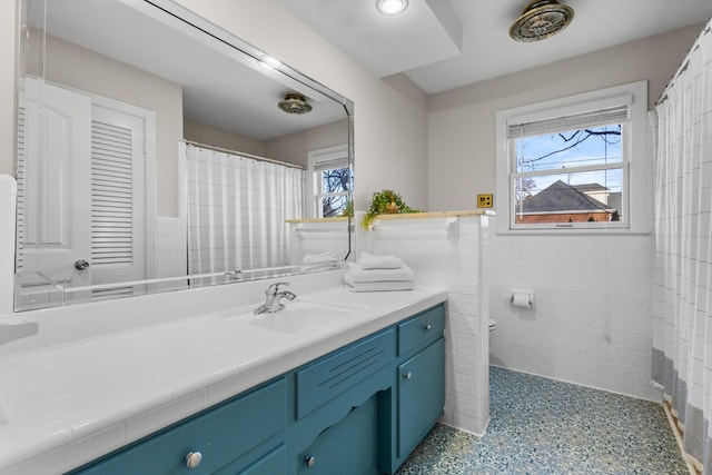 bathroom with vanity and tile walls