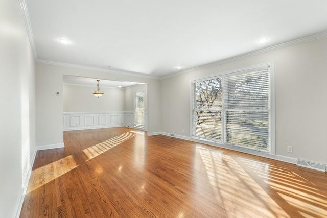 empty room with wood-type flooring and crown molding