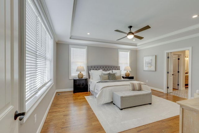 bedroom featuring crown molding, ceiling fan, a tray ceiling, and multiple windows