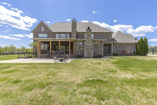 rear view of property with a lawn and a patio