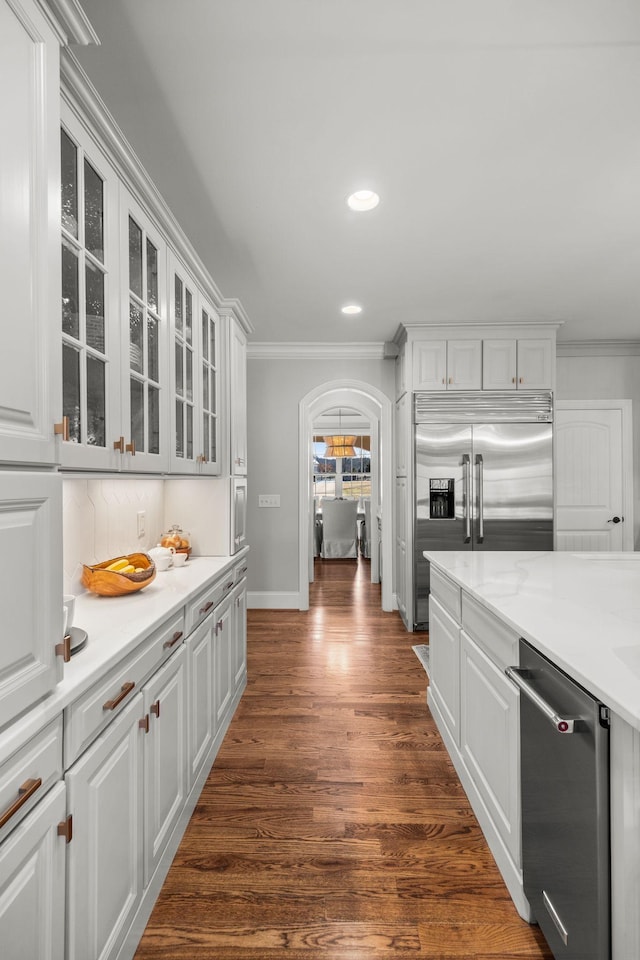 kitchen with appliances with stainless steel finishes, white cabinets, and ornamental molding