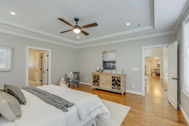 bedroom featuring a raised ceiling, ceiling fan, crown molding, and light hardwood / wood-style flooring