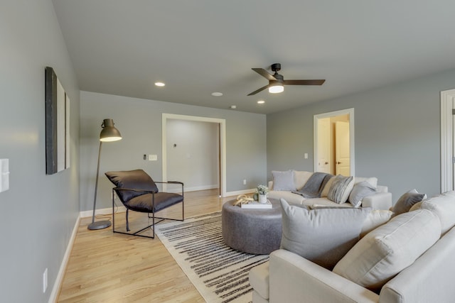 living room with ceiling fan and light hardwood / wood-style flooring