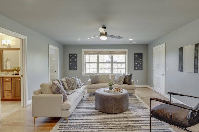 living room featuring light wood-type flooring and ceiling fan