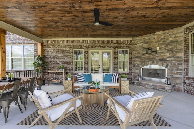 view of patio featuring french doors, ceiling fan, and an outdoor living space with a fireplace