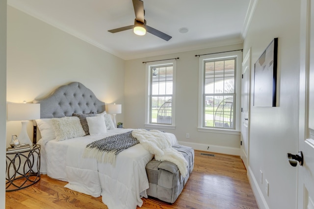 bedroom with ornamental molding, light wood-type flooring, and ceiling fan