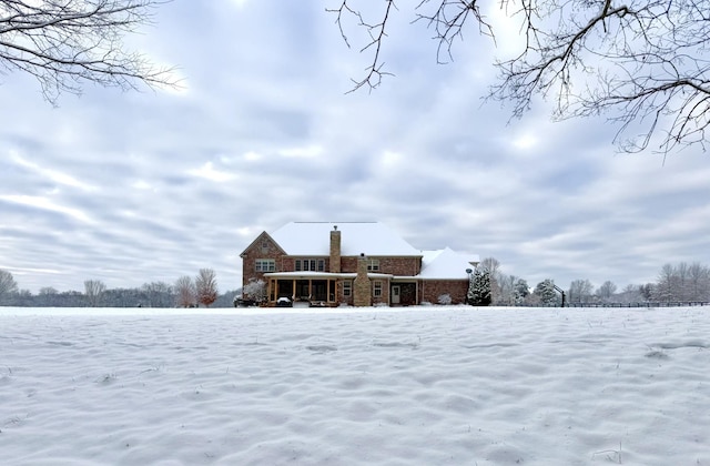 view of snow covered back of property