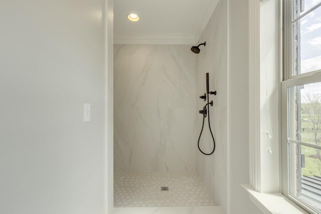 bathroom with crown molding, tiled shower, and a wealth of natural light