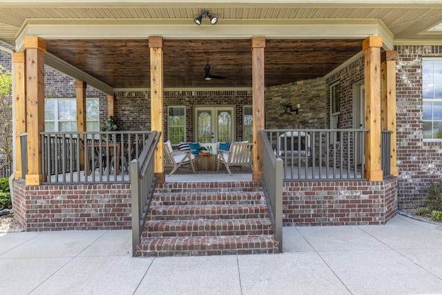 entrance to property featuring french doors, covered porch, and ceiling fan