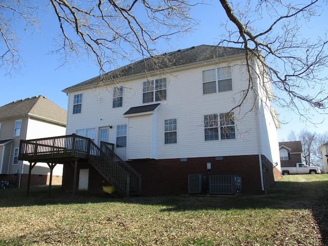 rear view of house featuring central AC unit, a wooden deck, and a lawn