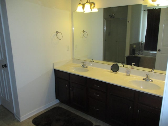 bathroom with a tub to relax in, vanity, and an inviting chandelier