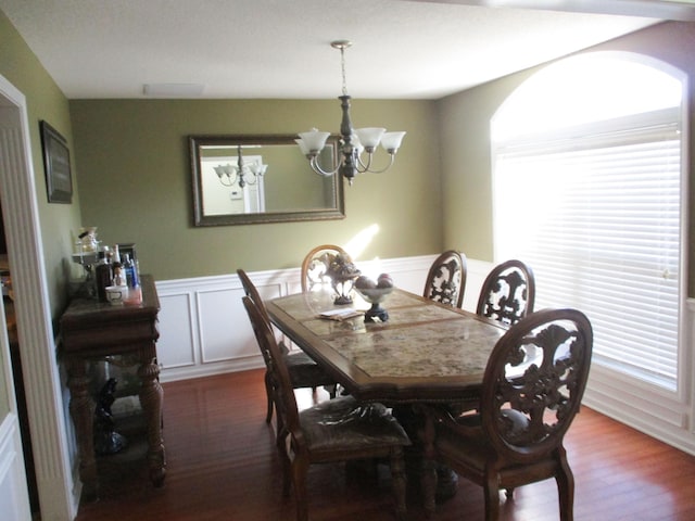 dining space with hardwood / wood-style flooring and a chandelier