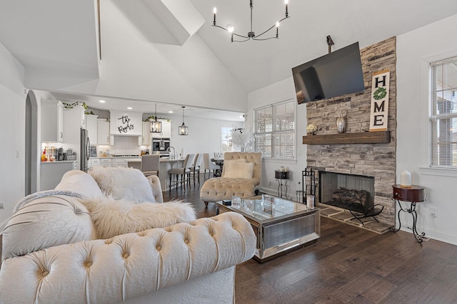 living room featuring dark hardwood / wood-style flooring, a stone fireplace, plenty of natural light, and high vaulted ceiling