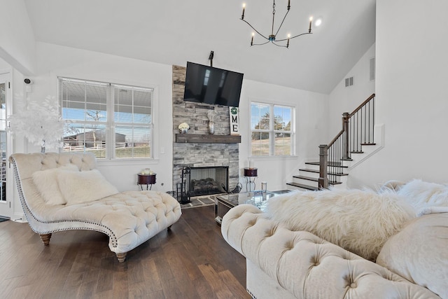 living room featuring dark hardwood / wood-style flooring, a fireplace, a wealth of natural light, and an inviting chandelier