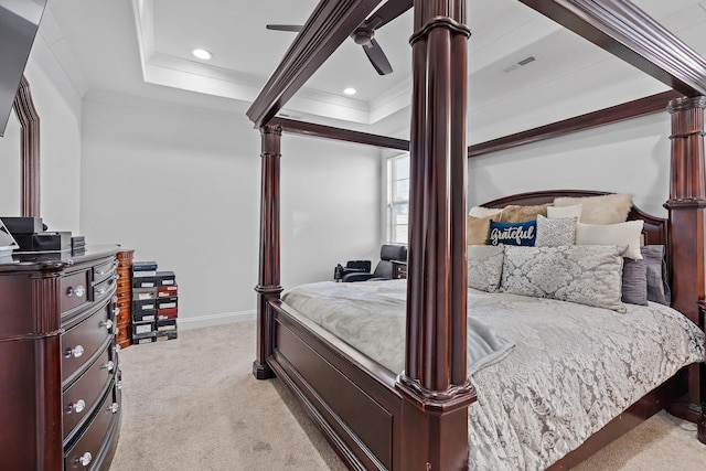 bedroom featuring ceiling fan, ornamental molding, a tray ceiling, and light colored carpet