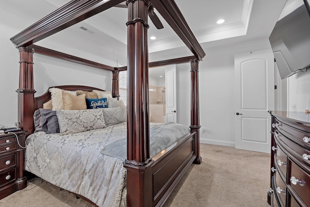 bedroom featuring ensuite bathroom, crown molding, light carpet, a tray ceiling, and ceiling fan