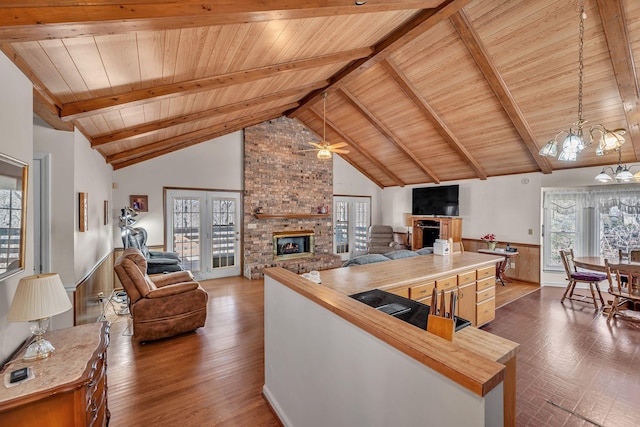 kitchen featuring high vaulted ceiling, a fireplace, beamed ceiling, wooden counters, and wood ceiling