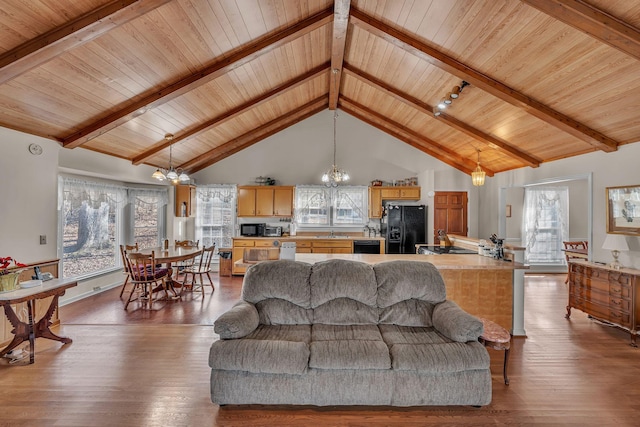 living room with a notable chandelier, wood-type flooring, and a healthy amount of sunlight