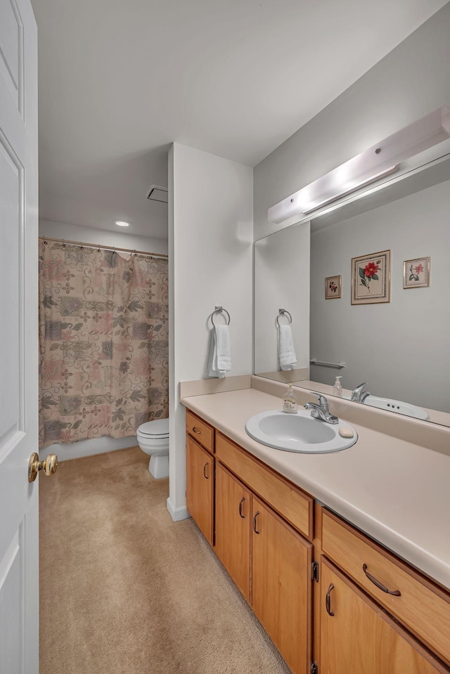 bathroom with walk in shower, vanity, and toilet