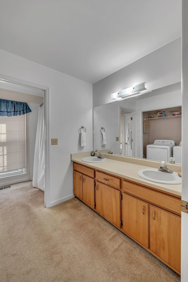 bathroom featuring vanity, washing machine and clothes dryer, and toilet