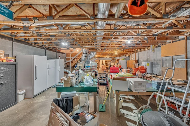 basement with water heater and white fridge