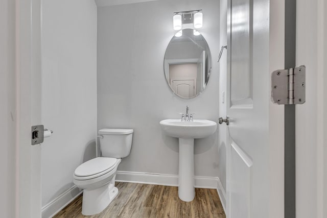 bathroom featuring wood-type flooring, sink, and toilet