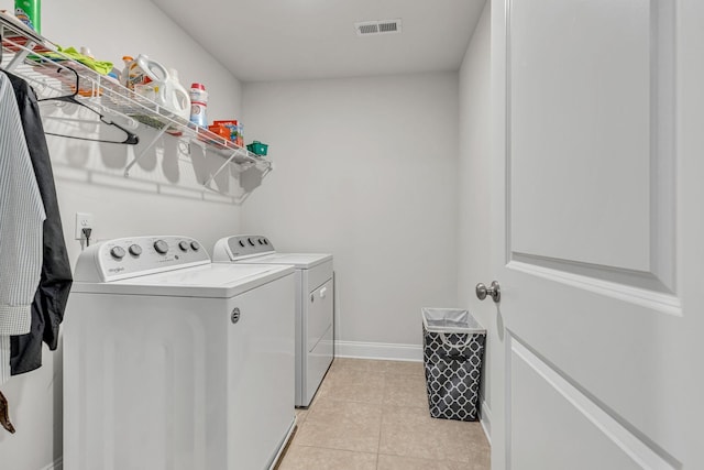 laundry area featuring light tile patterned flooring and washing machine and clothes dryer