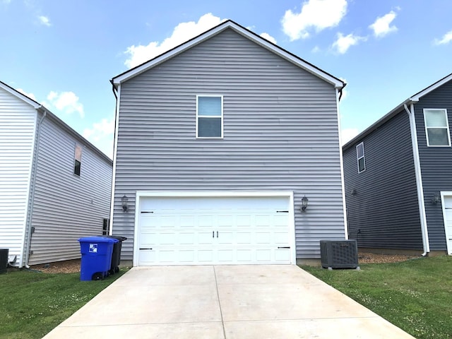 view of property exterior with a yard, central AC unit, and a garage