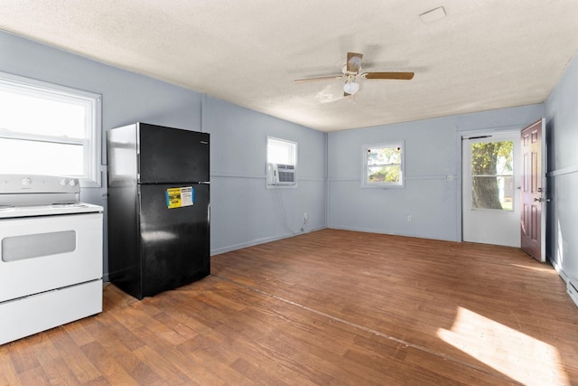 kitchen featuring hardwood / wood-style floors, black refrigerator, electric stove, ceiling fan, and a textured ceiling