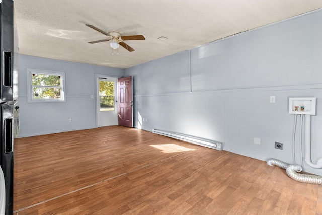 interior space with ceiling fan, baseboard heating, a textured ceiling, and hardwood / wood-style flooring