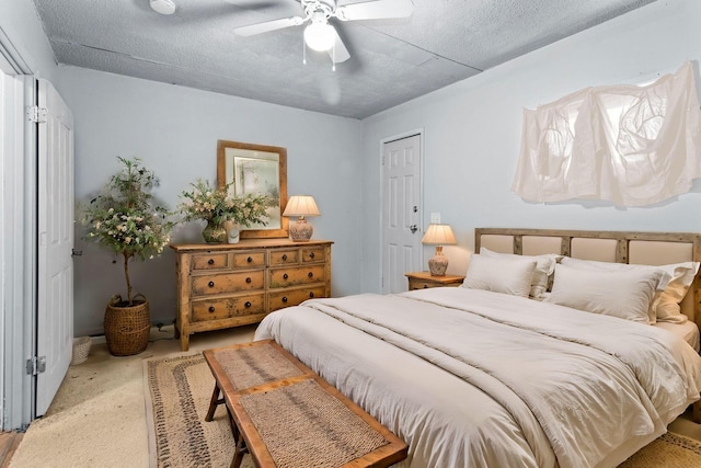 bedroom featuring a closet, a textured ceiling, ceiling fan, and light colored carpet