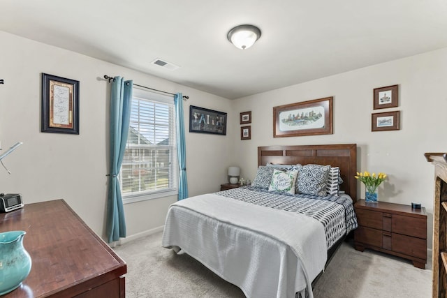 bedroom with light carpet and a fireplace